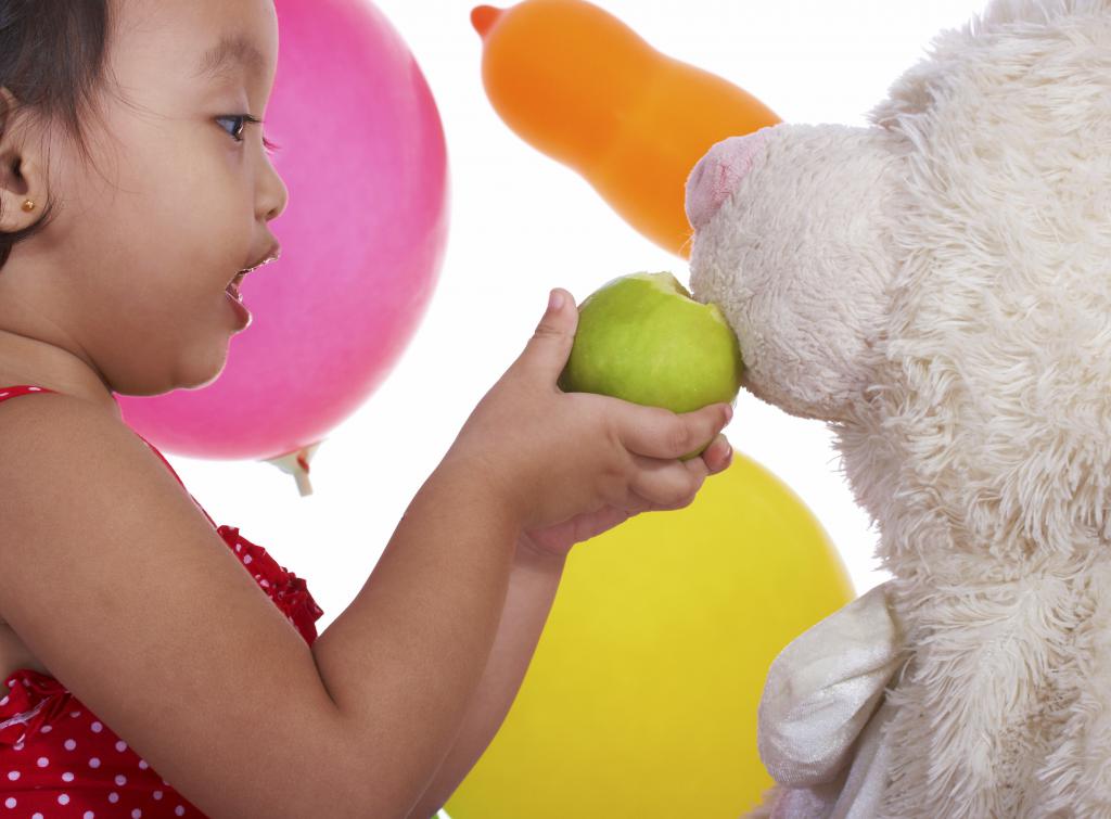 djevojka hranjenja jabuka pas igračka