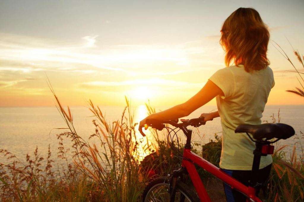 ragazza con una bicicletta a guardare il tramonto